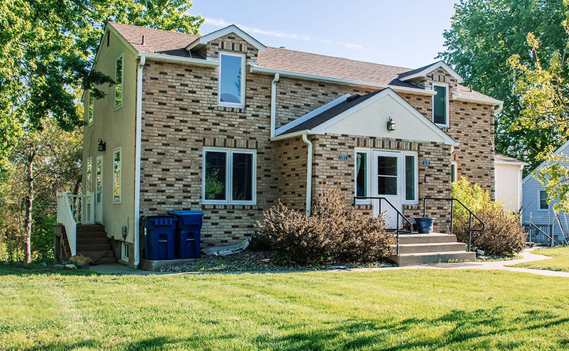 Exterior view of a brick house with a green lawn