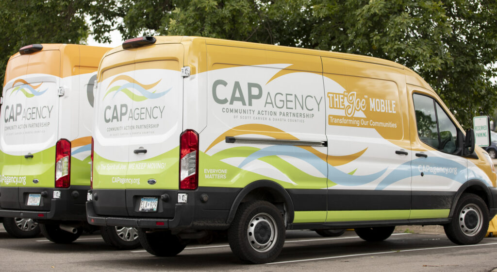 A white CAP Agency mobile food shelf van parked outdoors.